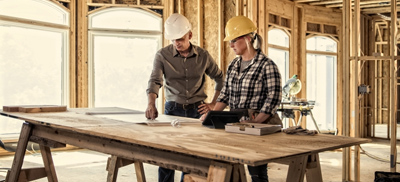 Image of 2 people looking at blueprints on the job